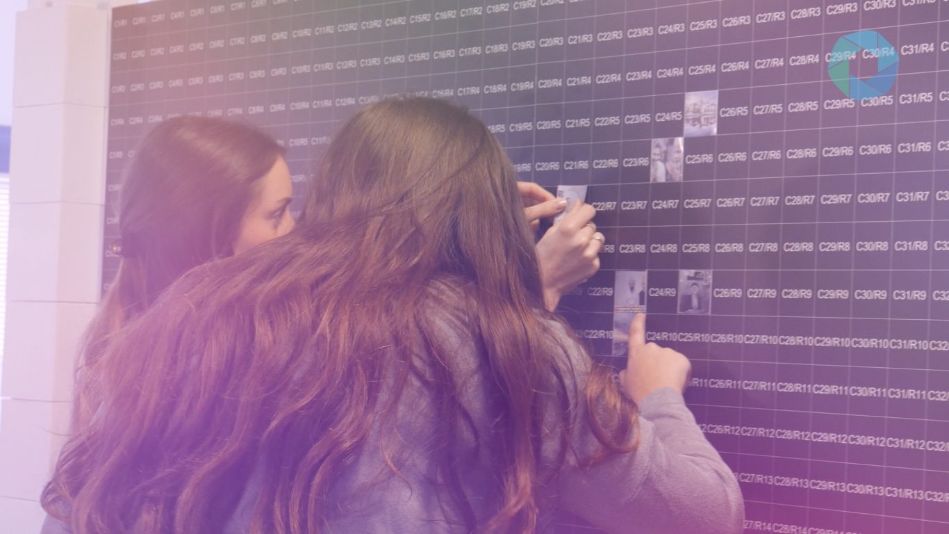 Gäste platzieren ihre Fotos an der Fotomosaikwand